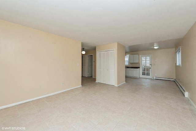 unfurnished living room featuring baseboard heating