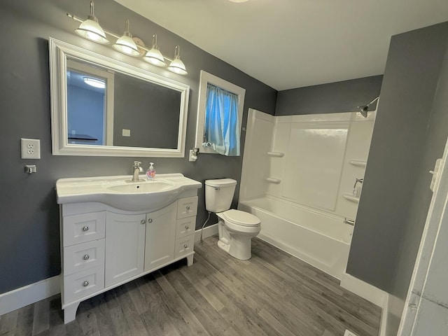 full bathroom with hardwood / wood-style flooring, vanity, tub / shower combination, and toilet