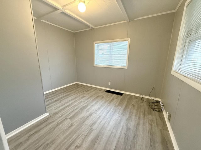 empty room featuring crown molding and hardwood / wood-style flooring