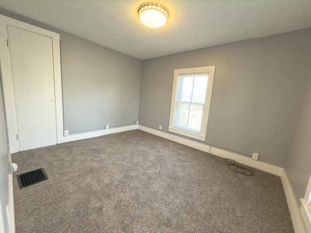 unfurnished room with carpet floors and a textured ceiling