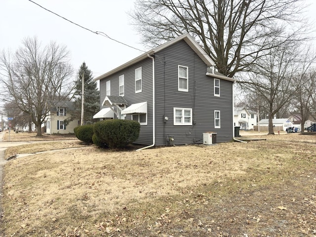 view of home's exterior featuring central AC unit and a lawn