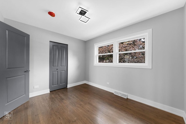 unfurnished bedroom featuring dark wood-type flooring