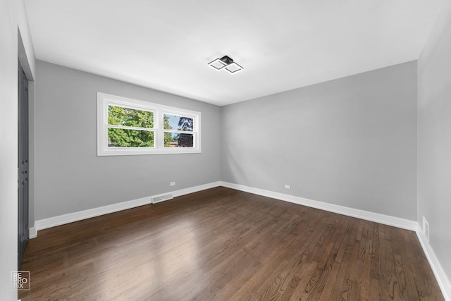 unfurnished room with dark wood-type flooring