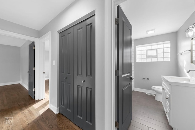 hall featuring sink and dark wood-type flooring