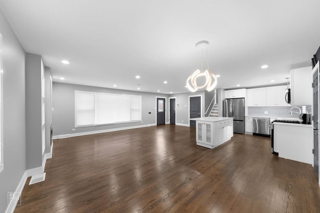 kitchen featuring stainless steel appliances, white cabinets, a kitchen island, dark hardwood / wood-style flooring, and decorative light fixtures