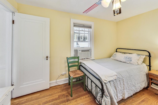 bedroom with cooling unit and light wood-type flooring