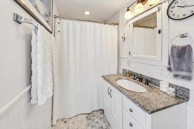 bathroom featuring vanity and tile walls