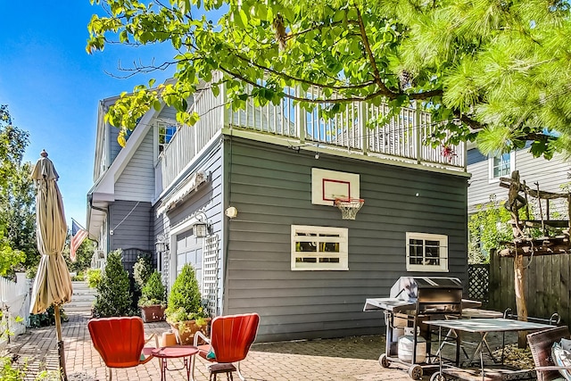 rear view of property featuring a patio and a balcony