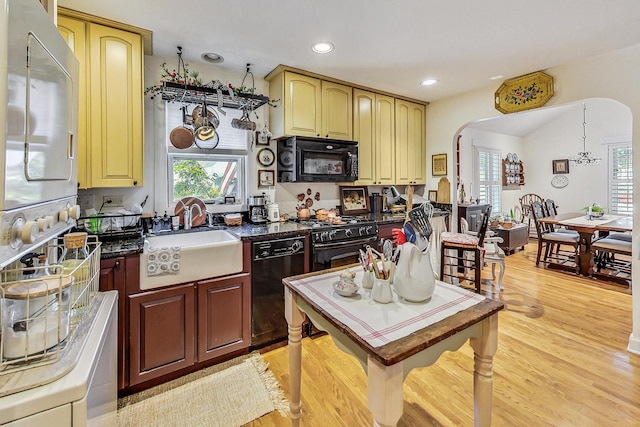 kitchen with sink, light hardwood / wood-style flooring, and black appliances