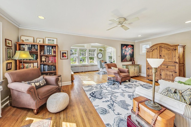 living room featuring crown molding, wood-type flooring, and a wealth of natural light