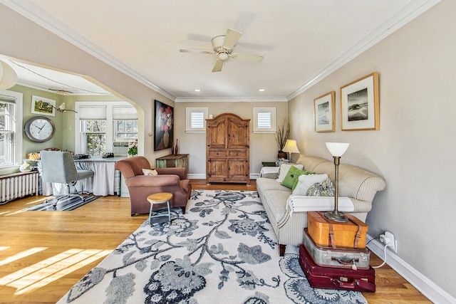 living room featuring crown molding, radiator, hardwood / wood-style flooring, and a healthy amount of sunlight