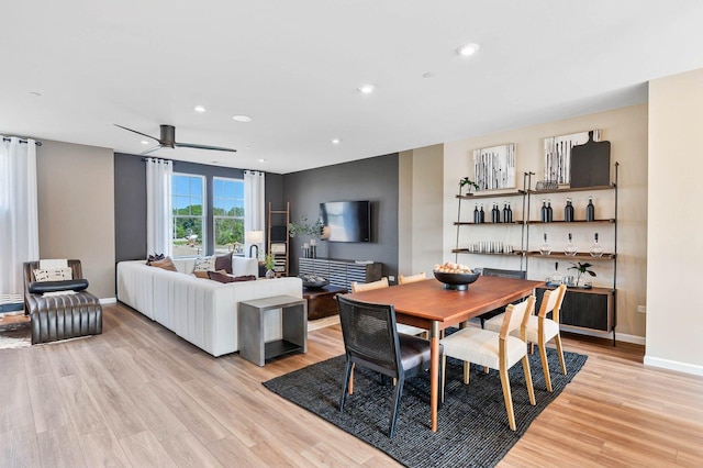 dining space with ceiling fan and light wood-type flooring