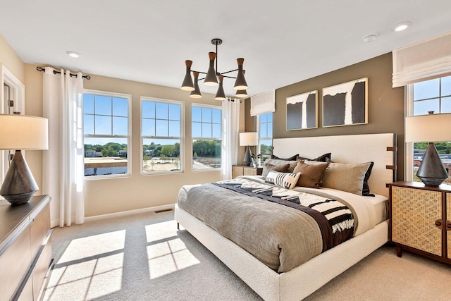 bedroom featuring light colored carpet and an inviting chandelier