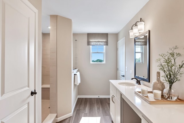 bathroom with wood-type flooring, a shower, and a wealth of natural light