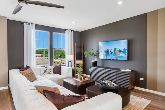 living room with dark wood-type flooring and ceiling fan