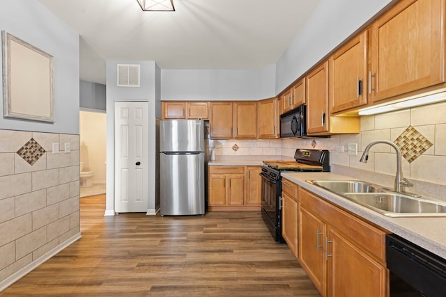 kitchen with sink, backsplash, black appliances, and dark hardwood / wood-style floors