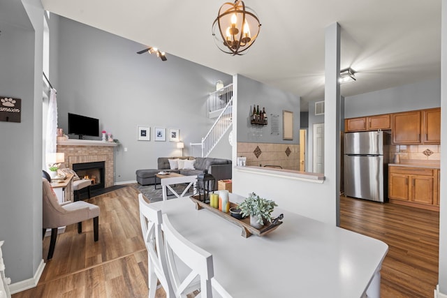 dining area featuring hardwood / wood-style flooring and a brick fireplace