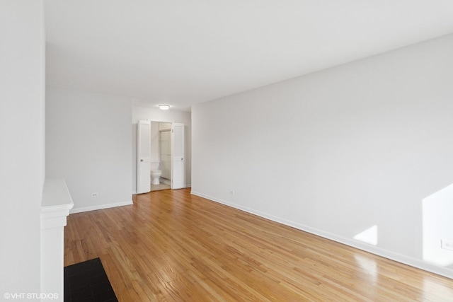 unfurnished room featuring baseboards and light wood-type flooring