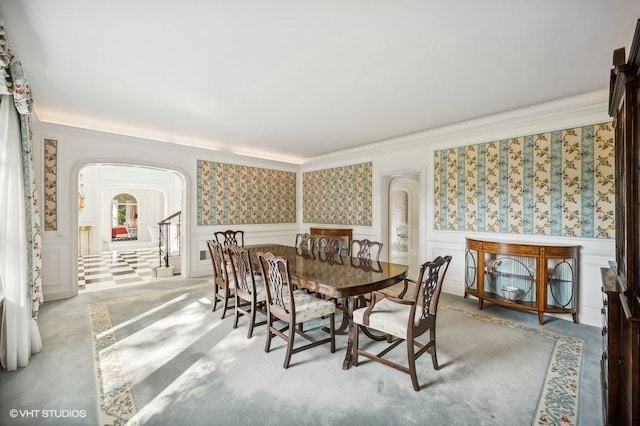 dining area featuring crown molding and light carpet