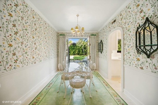 dining area with ornamental molding and a notable chandelier