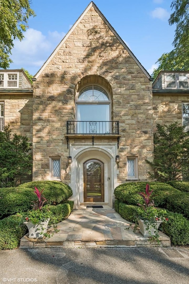 view of exterior entry with a balcony