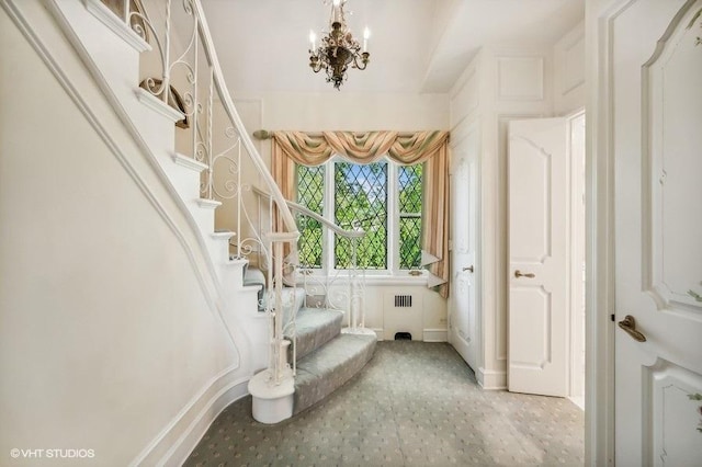 stairs featuring radiator and a notable chandelier