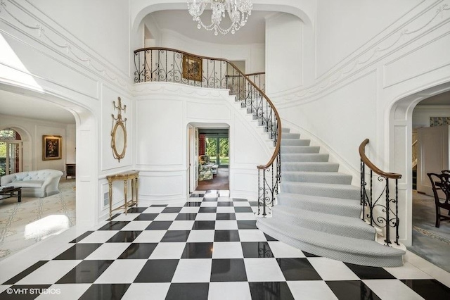 entrance foyer featuring a healthy amount of sunlight, a towering ceiling, and an inviting chandelier