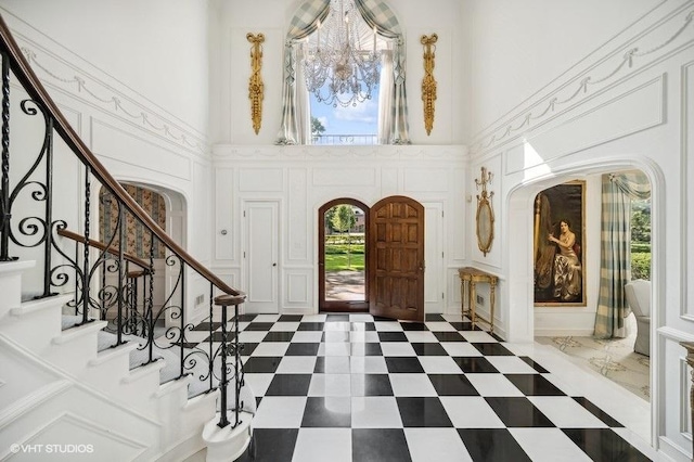 entrance foyer featuring a healthy amount of sunlight, a chandelier, and a high ceiling