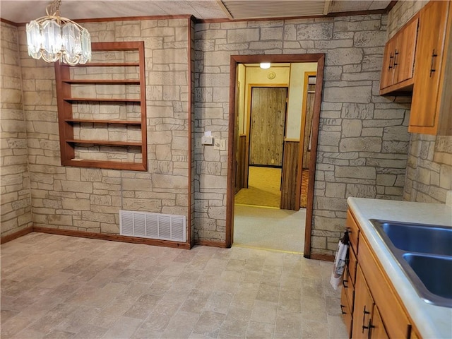 interior space with pendant lighting, a chandelier, and sink