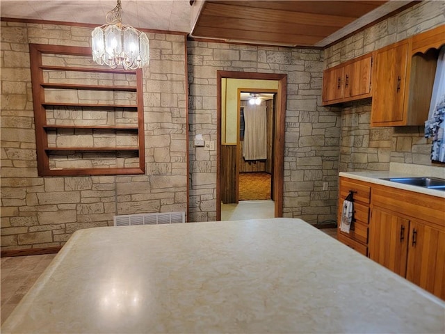 kitchen with hanging light fixtures, crown molding, and wood ceiling