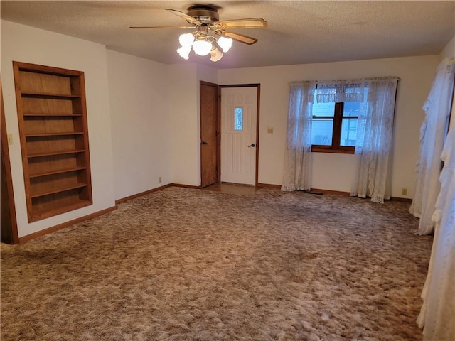 entryway featuring ceiling fan, carpet, and a textured ceiling