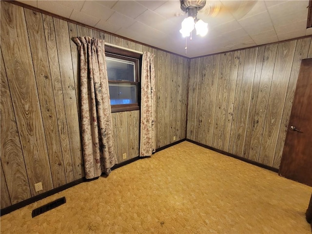 spare room with light colored carpet and wooden walls