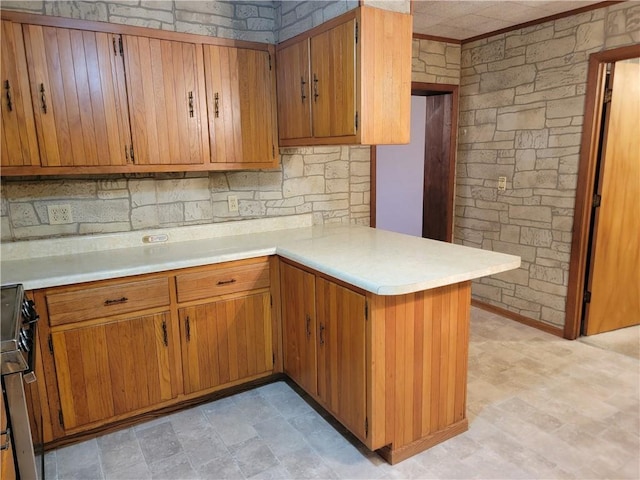 kitchen featuring tasteful backsplash, range, and kitchen peninsula