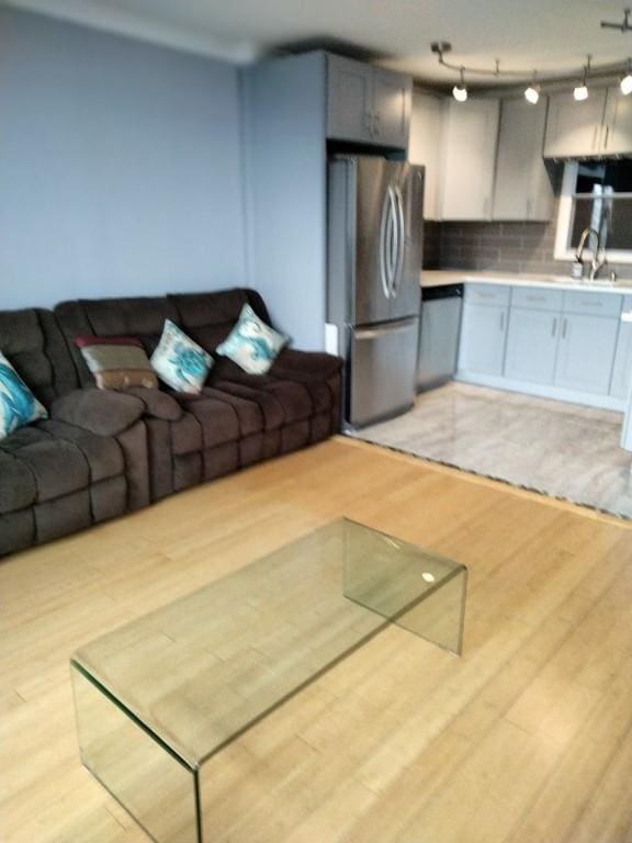 unfurnished living room featuring sink and light wood-type flooring