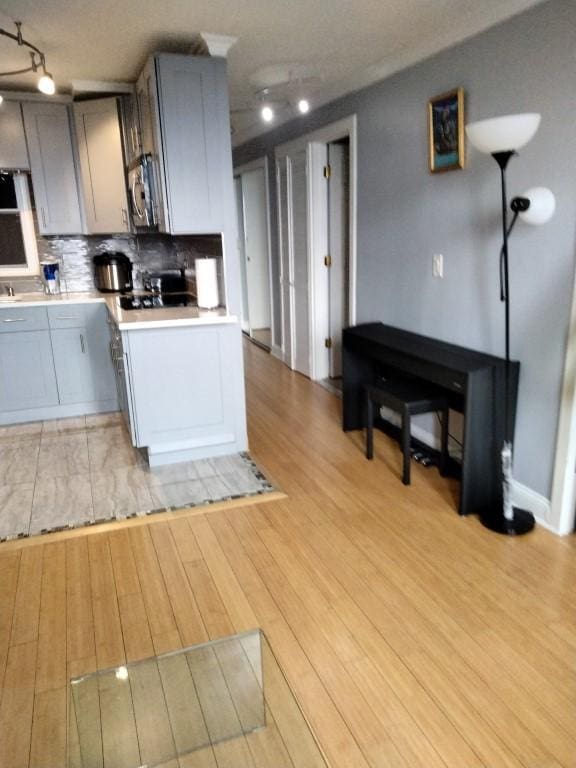 kitchen featuring tasteful backsplash, gray cabinets, and light hardwood / wood-style floors