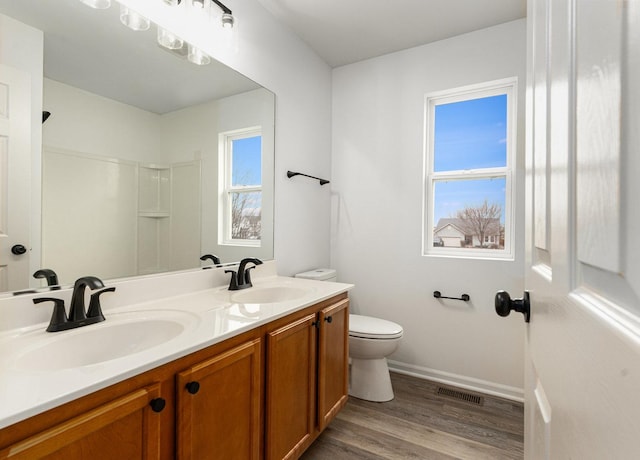 bathroom featuring vanity, wood-type flooring, and toilet