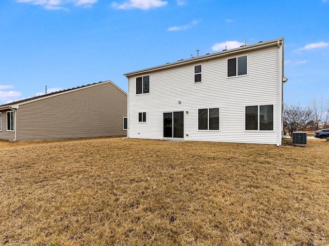 rear view of house featuring a lawn and central air condition unit