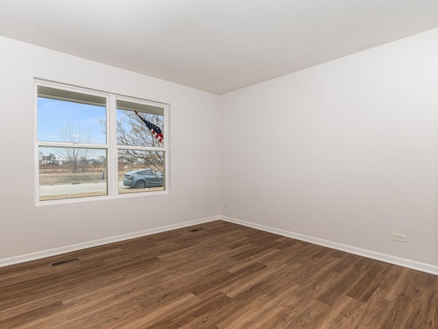 spare room with dark hardwood / wood-style flooring