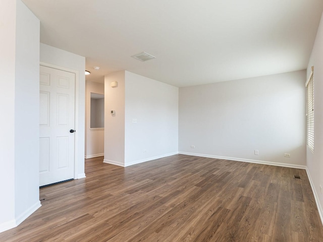 spare room featuring dark wood-type flooring