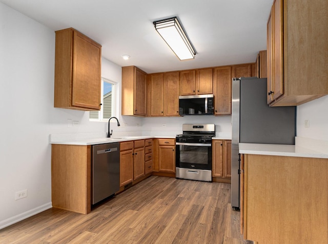 kitchen with dark wood-type flooring, appliances with stainless steel finishes, and sink