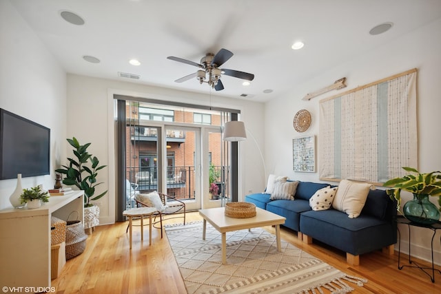 living room featuring ceiling fan and light hardwood / wood-style floors