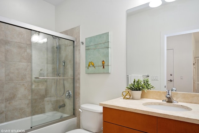 full bathroom featuring vanity, bath / shower combo with glass door, and toilet