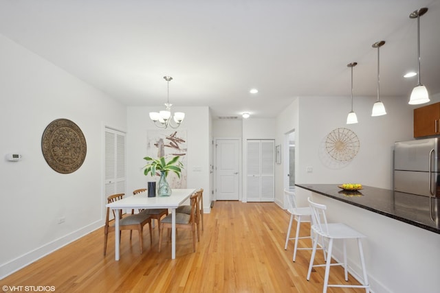 dining room featuring an inviting chandelier and light wood-type flooring