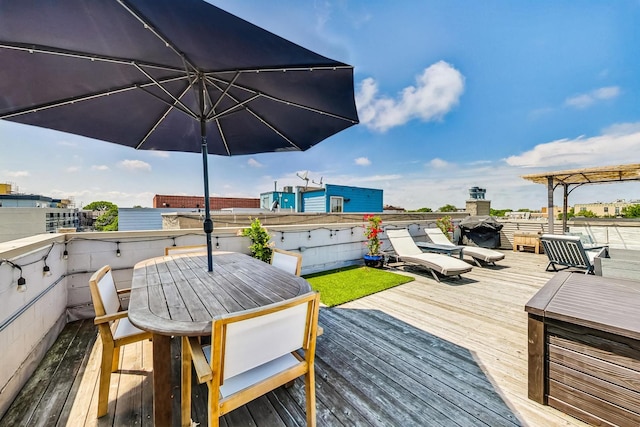 deck with grilling area and a hot tub