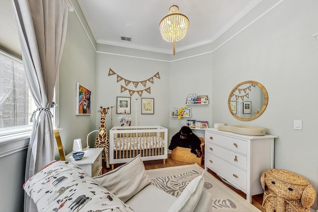 bedroom with hardwood / wood-style floors, crown molding, and a notable chandelier