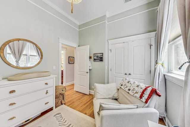 living area featuring ornamental molding and light hardwood / wood-style floors