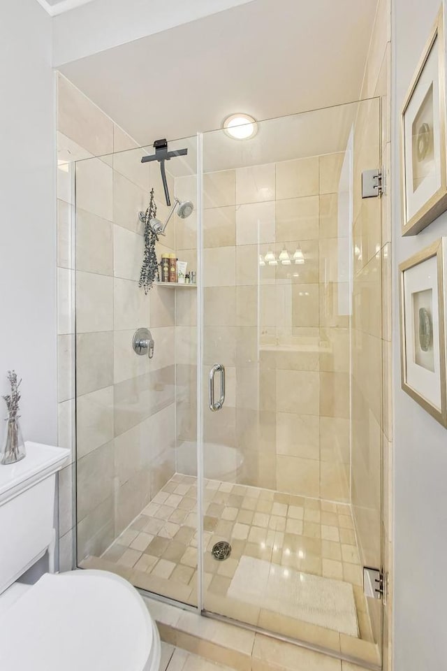 bathroom with toilet and a shower with shower door