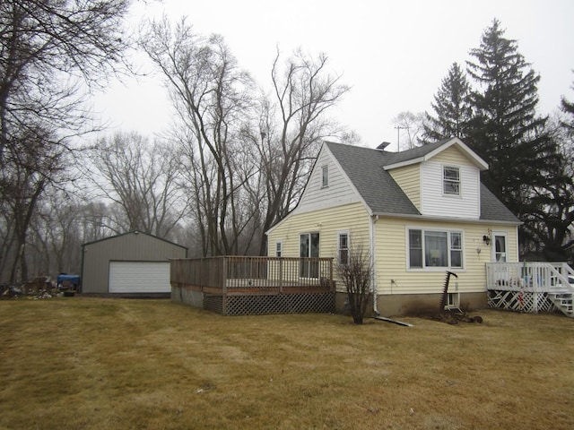 rear view of property with a garage, an outdoor structure, a yard, and a deck