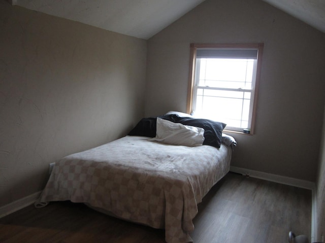 bedroom featuring lofted ceiling and dark hardwood / wood-style flooring