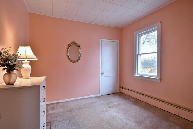 interior space with a baseboard heating unit and light colored carpet